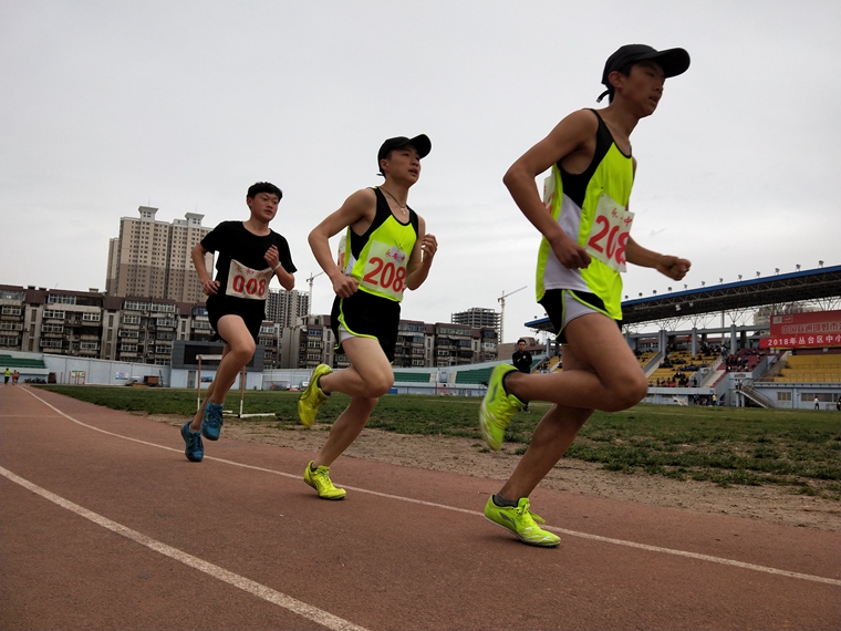 运动会上参加田径项目的学生在奋力奔跑.jpg
